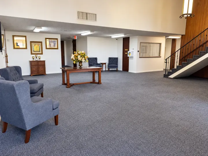Main lobby seating area with armchairs and a wooden staircase