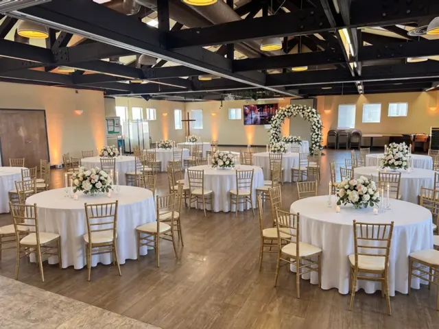 AI design concept of the hall decorated for a wedding reception with white linens, gold chairs and florals