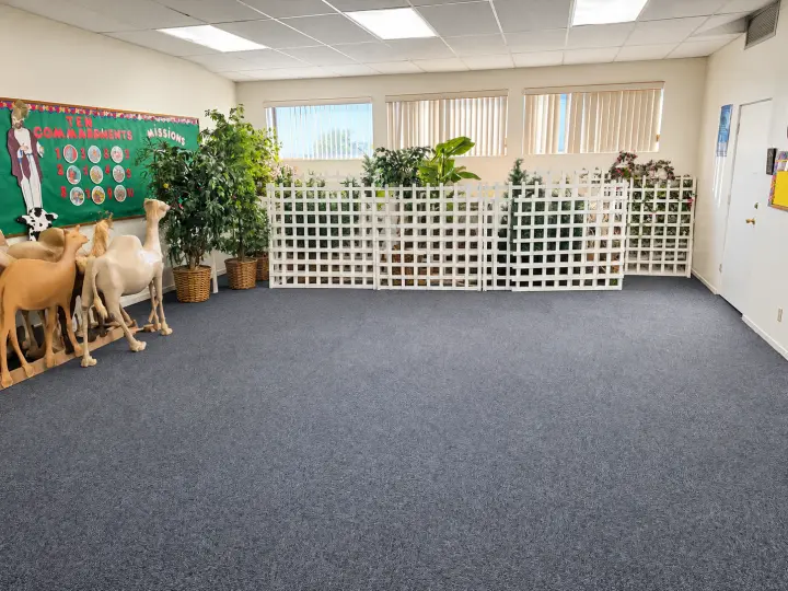 Children's ministry room with a bulletin board, lattice divider, plants and nativity animal figures