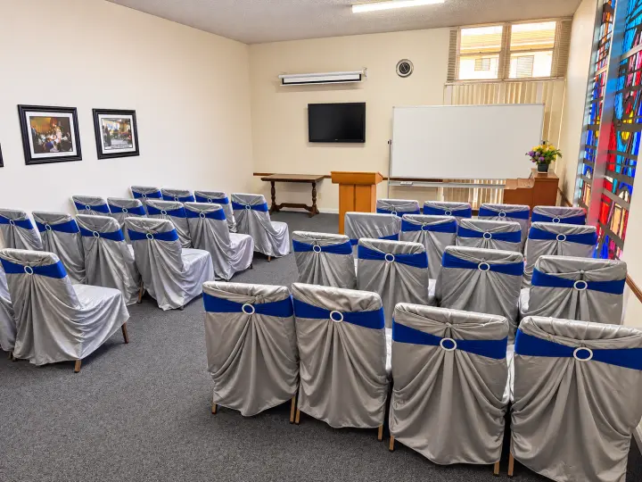 Meeting room with chairs facing a whiteboard and podium